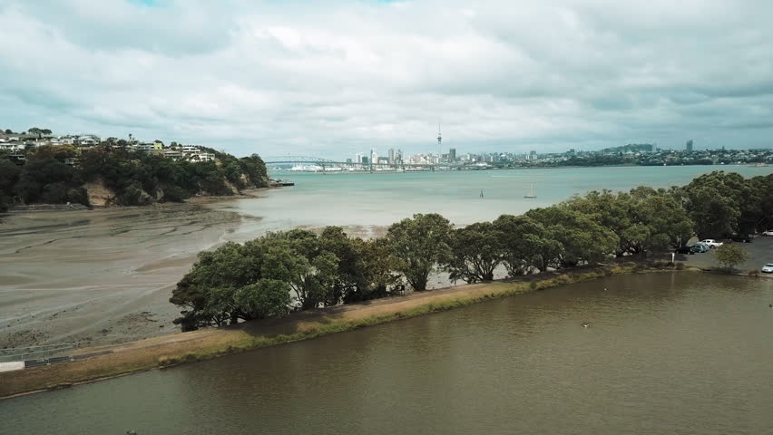 drone over Auckland Harbour with view of Bridge and Sky Tower