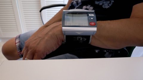 A male person checking his blood pressure at home