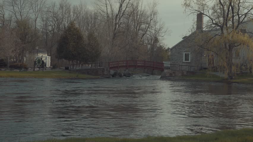 Peaceful scenic view of the Tay River flowing under a walking bridge in Perth, Ontario at sunset