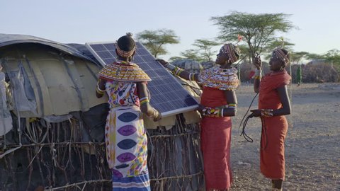 Tribal women installing solar panel. Kenya