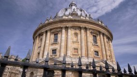 Camera slides past railings with Radcliffe Camera in Oxford behind. Taken on a sunny summer morning in 2018