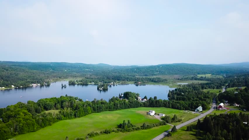 A wide aerial shot of the lake and a high speed boat jets across the surface. As it moves at high speed it zooms around a small island.