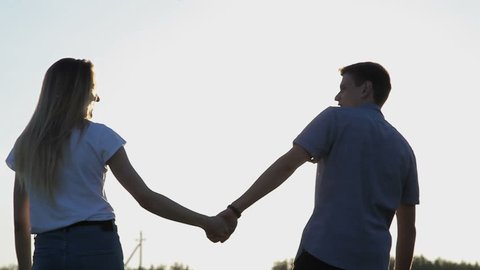 Guy and girl in love walk around holding hands
