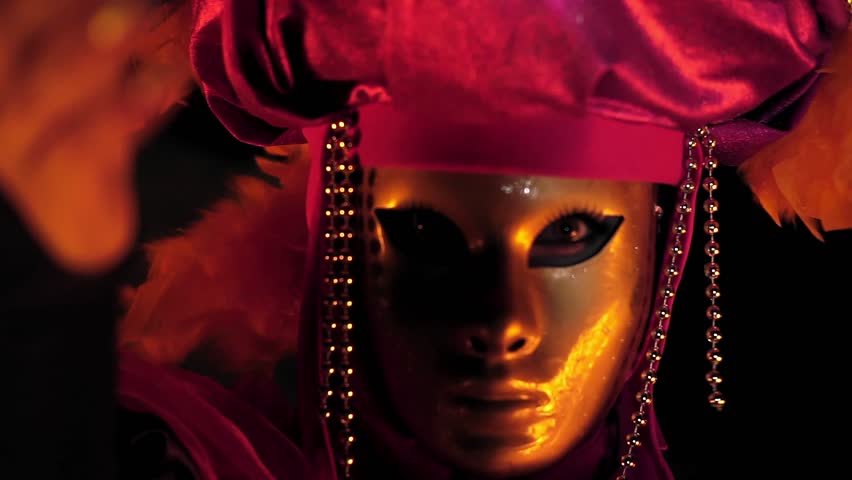 The face of the girl at the masquerade in a Venetian suit hides a mysterious mask. Dance with fire in the night. Concept idea for dance | Shutterstock HD Video #1016862850