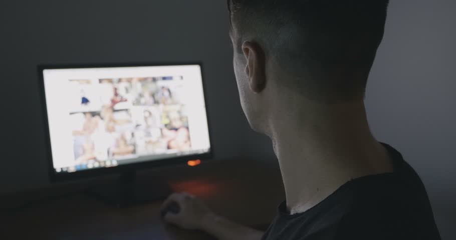 Young Man secretly watching porn sites at night.