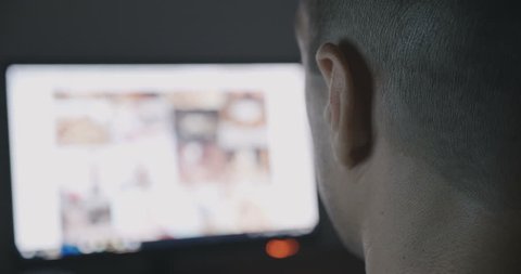 Back view of Young Man secretly watching porn sites at night. Closeup