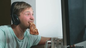 technology, games, entertainment, play and people concept. a young man playing a computer game at home, drinking beer and eating pizza. 4k, slow motion
