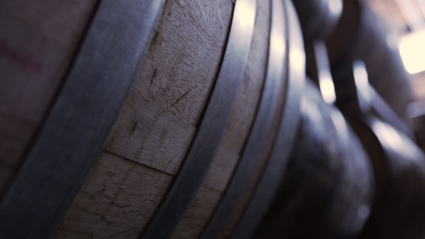 Dolly shot of wooden barrels in warehouse at brewery