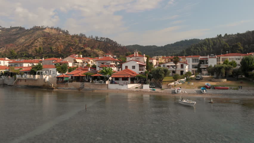 Aerial view of the small Greek village on the shore of the Aegean Sea, zoom in zoom out and panorama