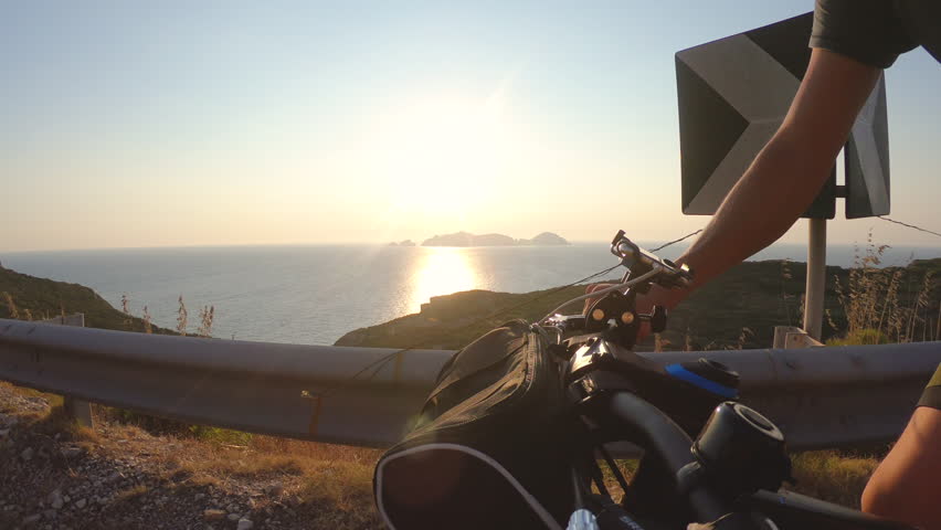 Athlete cyclist man cycling biking on road on ponza island at sunset in front of the sea.