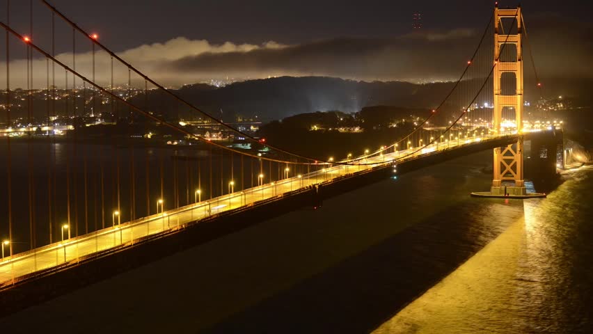 Time lapse shot of light trails on Golden Gate Bridge over San Francisco Bay at night