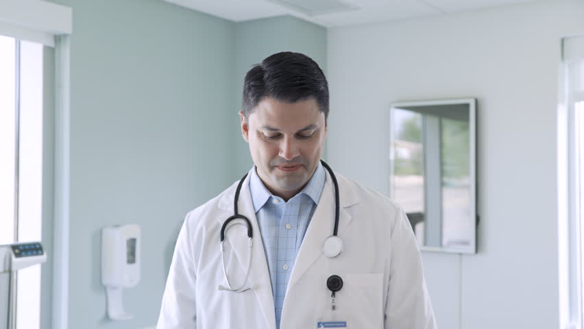 Dolly shot of happy male doctor wearing lab coat standing at hospital | Shutterstock HD Video #1016892739