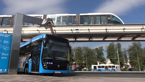 Moscow, Russia-September 2017:The concept of urban transport .Blue electric bus at the charging station.Modern train passing on the monorail. The concept of ecological future.