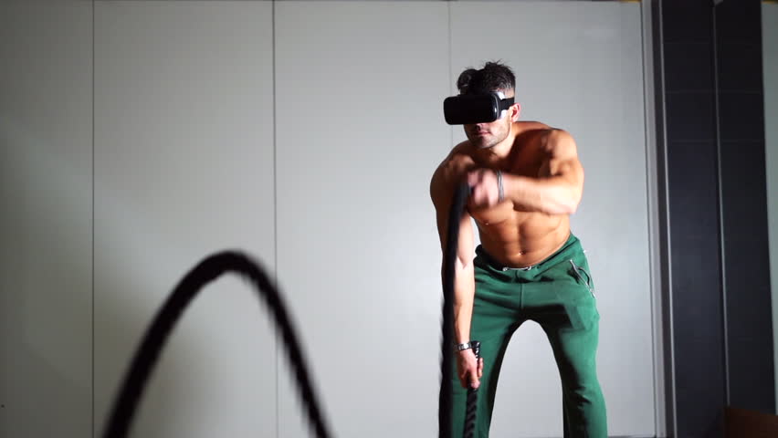 Sportsman using virtual reality technology during a training session at the gym. Sport and virtual reality concept. Two intensity training sessions. Slow motion 100fps.