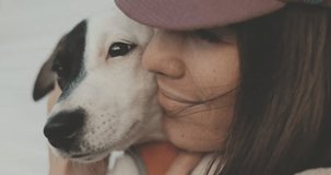 Portrait of beautiful young woman playing with dog jack russell terrier . A girl hugging and kissing a cute puppy. 4K video shooting