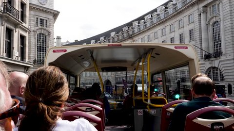 LONDON, ENGLAND-AUGUST 30, 2018: Passengers on the top open-air level of one of the many tour bus giving visitors the mobile tour of the streets of London