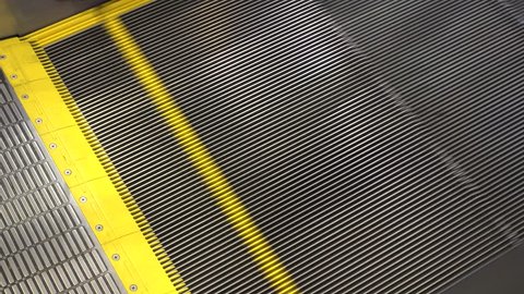 Escalator in metro, shopping mall. Moving up staircase escalator to Moving electric escalator.Close up floor platform electric escalator. yellow bands metal line steel. yellow gray steel line