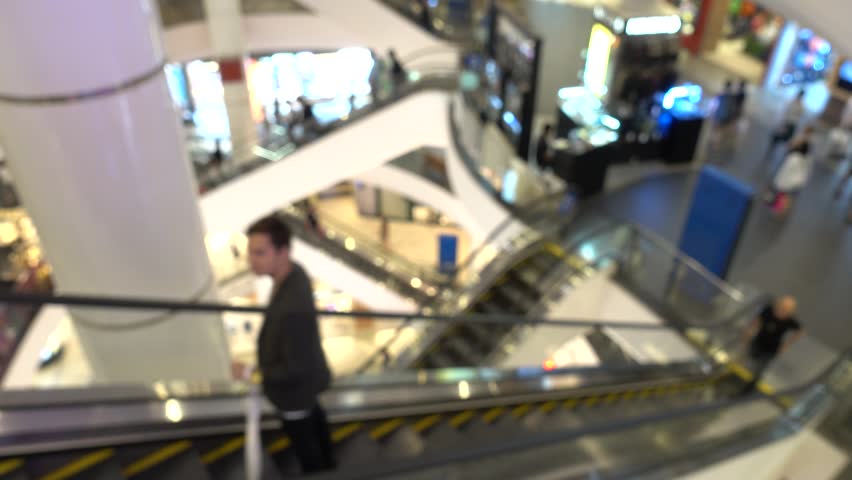 People in motion in escalators at the modern shopping mall. Abstract blurred motion background. | Shutterstock HD Video #1016908420