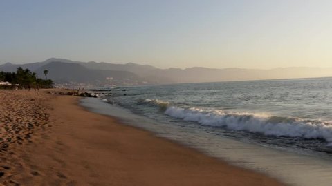 Waves from the Pacific Ocean crashing on the beach during a sunset in Puerto Vallarta, Jalisco, Mexico.