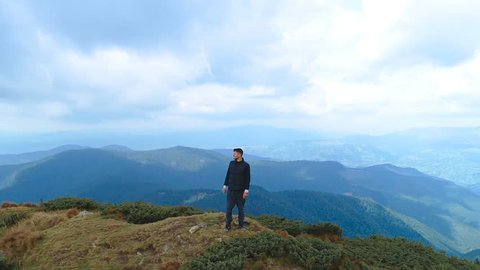 The happy man standing on the top of the mountain with a beautiful landscape