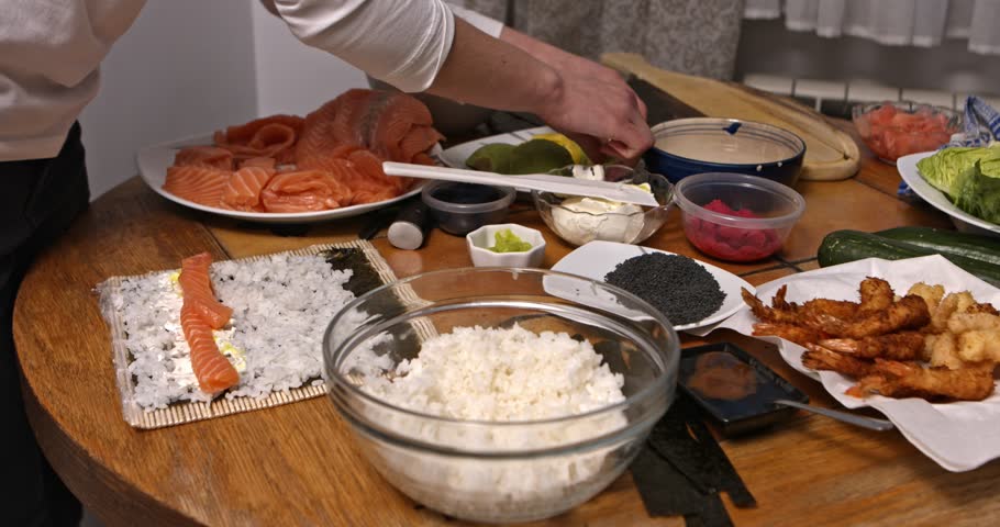 The wide view of table while woman making japanesse food, sushi.