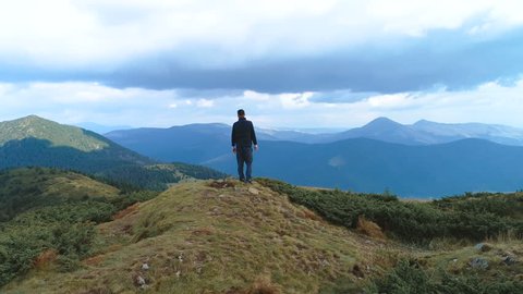 The man standing on the top of the mountain with a picturesque view