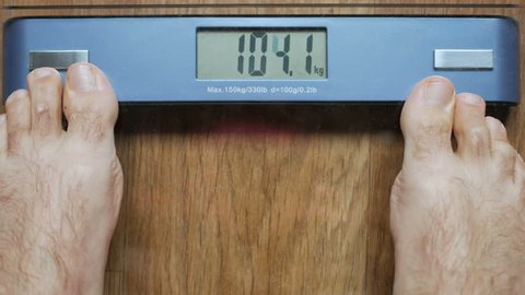 Man Standing On Weighing Scales #1 by Science Photo Library