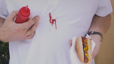Man accidentally squirts ketchup and stains shirt closeup 
