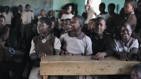 KISUMU,KENYA - MAY 21, 2018: Group of happy African children sitting in classroom and smiling, laughing together.