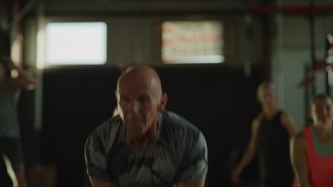 Fitness instructor encouraging man lifting kettle bell in gymnasium / Lehi, Utah, United States Stockvideo