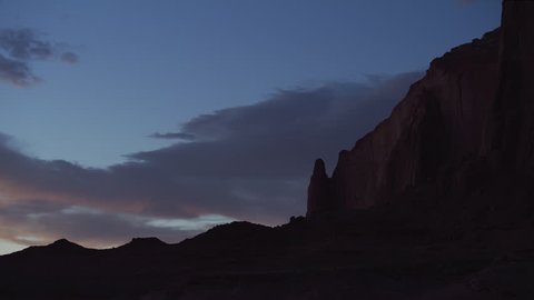 Day to night time lapse of clouds blowing over rock formation / Lake Powell, Utah, United States