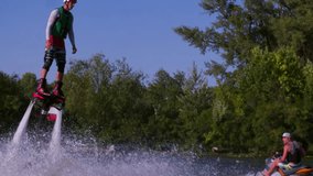 Flyboarder flying doing flip tricks slow motion Flyboarding medium shot video