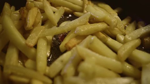 Spice french potatoes. French fries are fried in a frying pan. The potatoes are fried in a sunflower-seed oil.