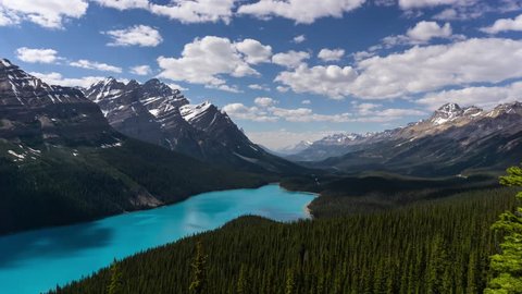 Beautiful aerial timelapse of a glacier lake in the Canadian Rocky Mountain Landscape during a vibrant cloudy summer day. Taken in Peyto Lake, Banff National Park, Alberta, Canada.