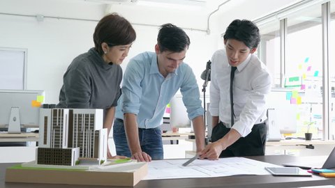 Architects team are working on paper blueprint and building model. Business woman suggest idea to designer. concept of construction, architecture, civil engineering, development and creative.