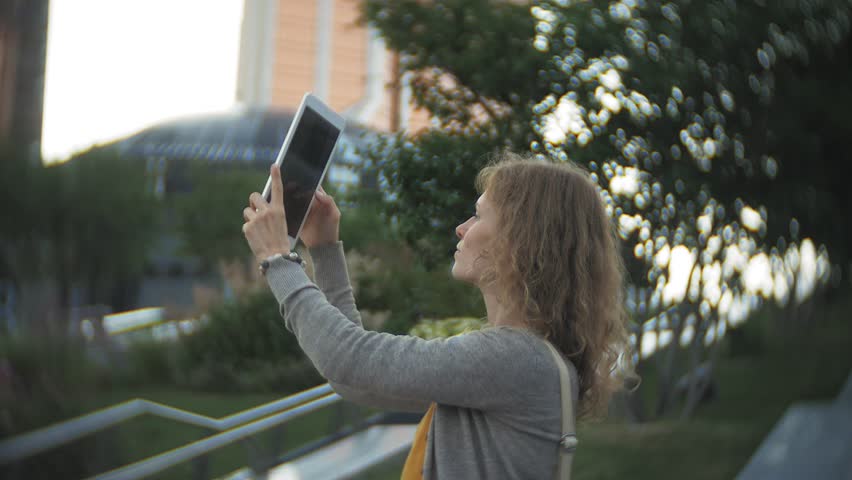 Young hipster woman is strolling in the city park business center 4k