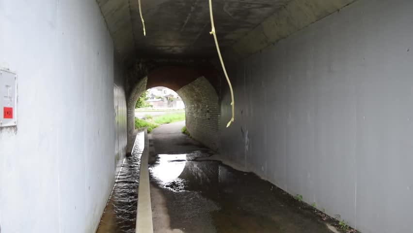 Observing a biker going through a small tunnel.