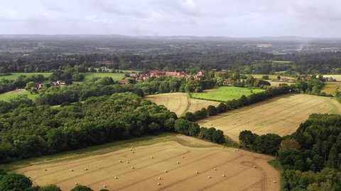 4K aerial forward over harvested fields late summer english countryside