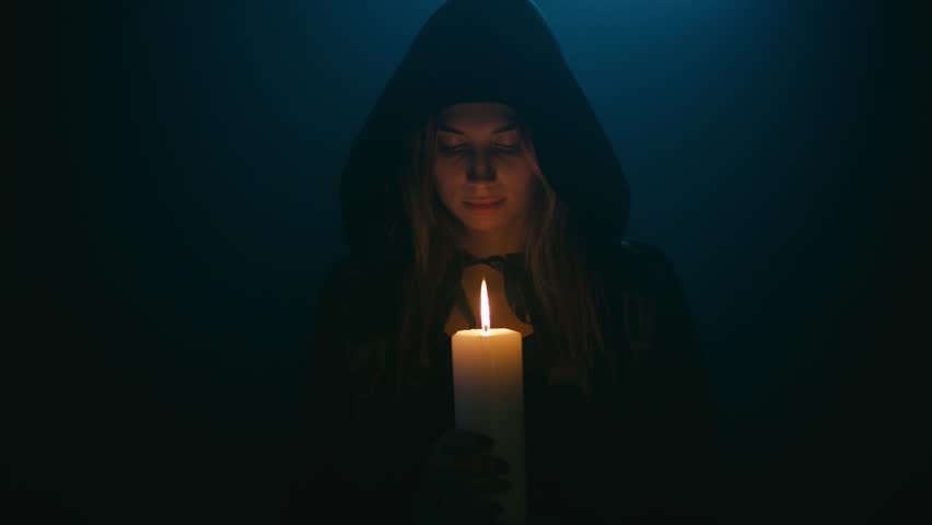 Woman in balck cape with candle, shallow depth of field