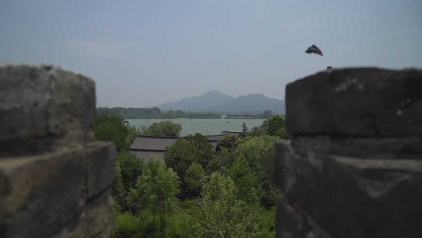 This shot was taken on the City Wall of Nanjing, China. In the distance some huge mountains can be seen. The foreground shows a lake in Nanjing.
