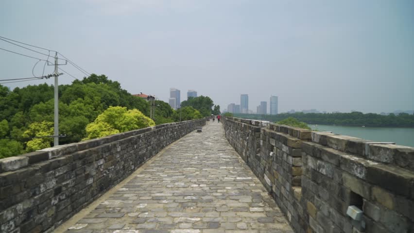 This is the City Wall of Nanjing in China. In the distance are the skyscrapers of downtown Nanjing. On the right side the river can be seen.