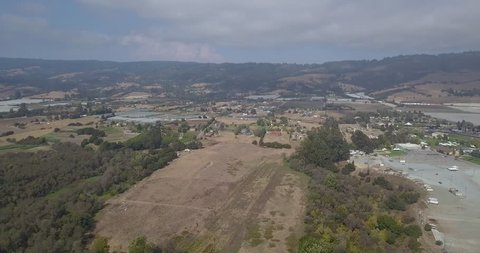 Smooth drone, dolly in, over large plot of land in Northern California, Watsonville. Mountain Range in background.