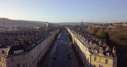 Aerial footage in City of Bath, of a street in bath with Georgian architecture buildings on either side, moving toward centre of Bath