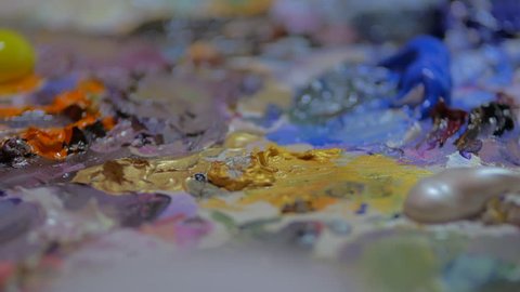 Extremem close up pan of paint palette colors brush dab