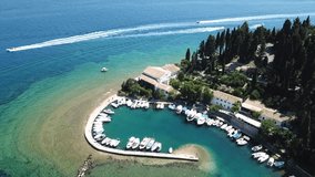Aerial drone video of iconic small port and fishing village of Kouloura with turquoise and emerald clear waters, Corfu island, Ionian, Greece