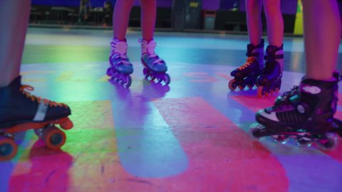 Slow motion shot of girls holding hands and jumping in circle at roller skating rink / Orem, Utah, United States: stockvideo