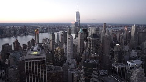 New York City Circa-2015, aerial view of Lower Manhattan at dusk, filmed from the East River, featuring the Financial District, Hudson River and Jersey City in the background