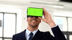 business, technology and augmented reality concept - businessman with chroma key green screen on vr glasses or headset at office