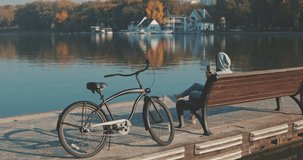Beautiful summertime mood shot of young woman or girl riding bicycle through promenade in sun light, 4K video shooting by handheld gimbal