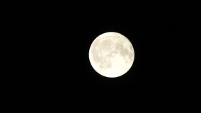Full Moon in a cloudy night sky with clouds moving around. Close up  4k video